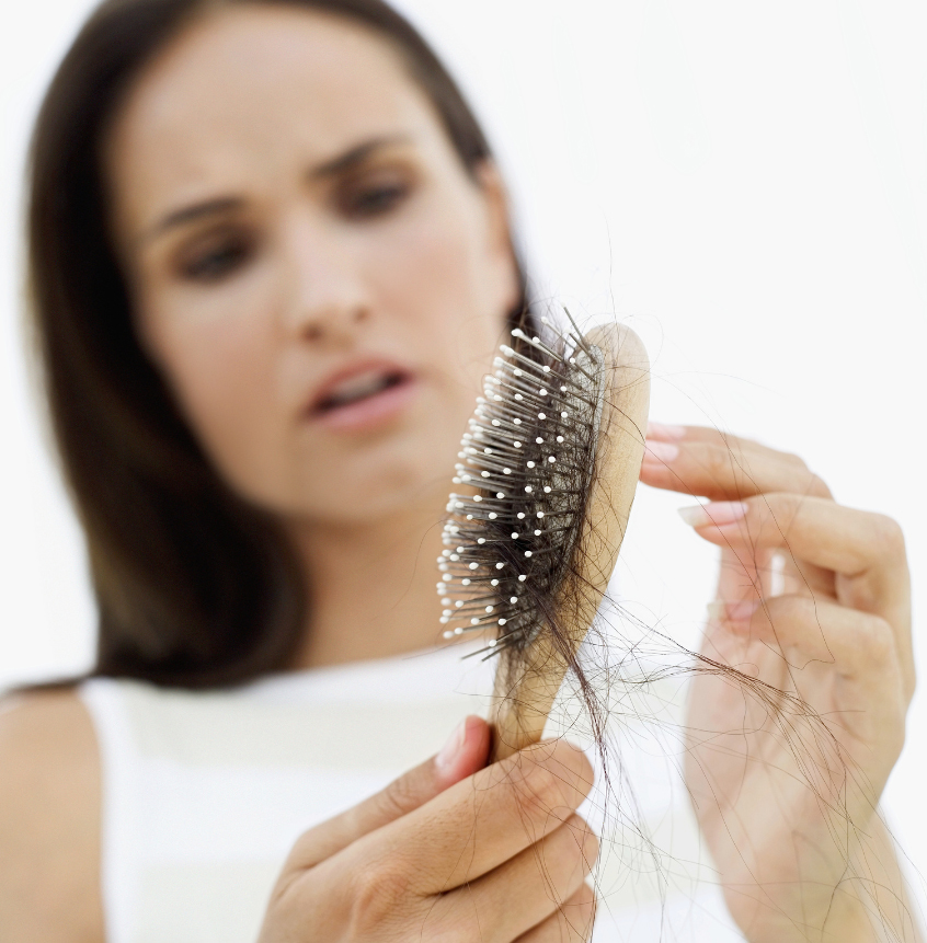 Woman examining thinning hair at her part
