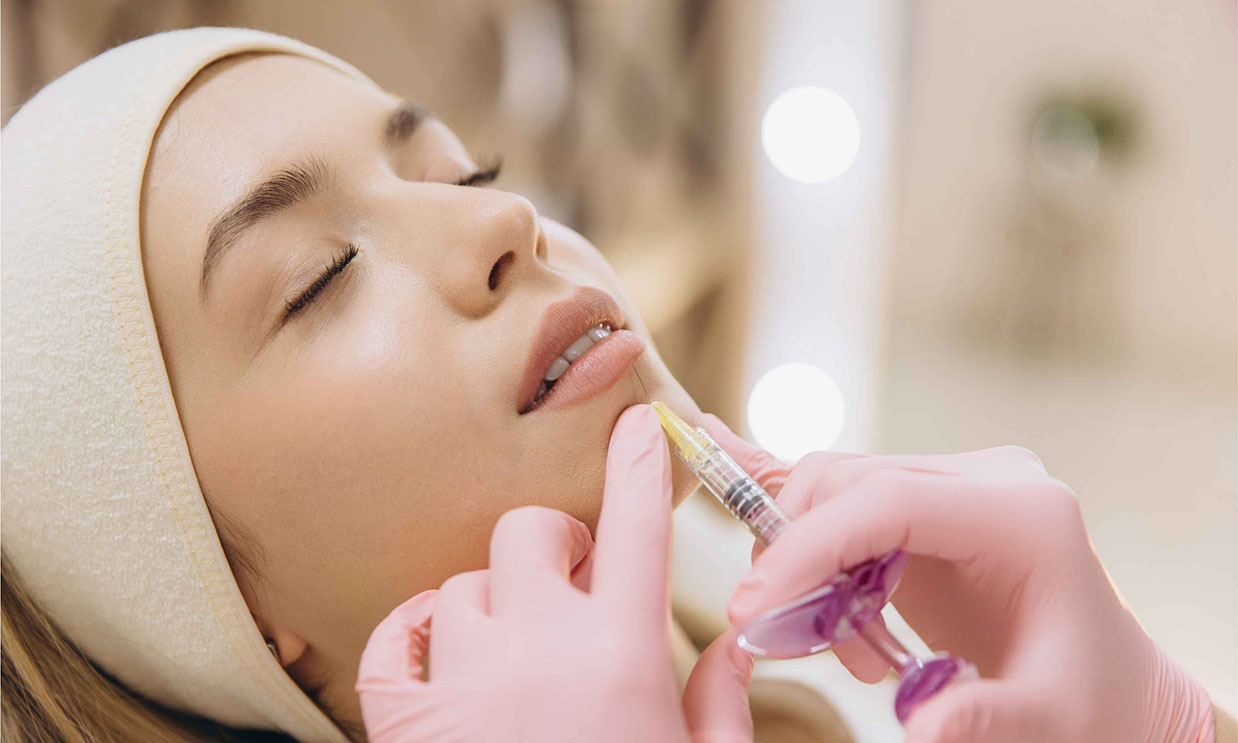A dermatologist administering hyaluronic acid lip filler
